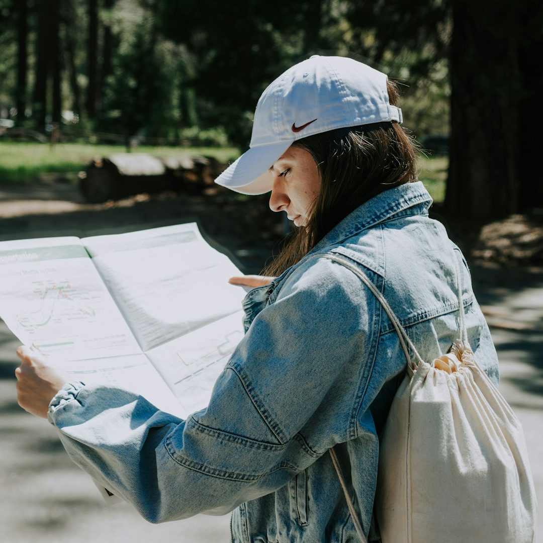 Photo by Kiril Krsteski Woman reads a map in a forest.